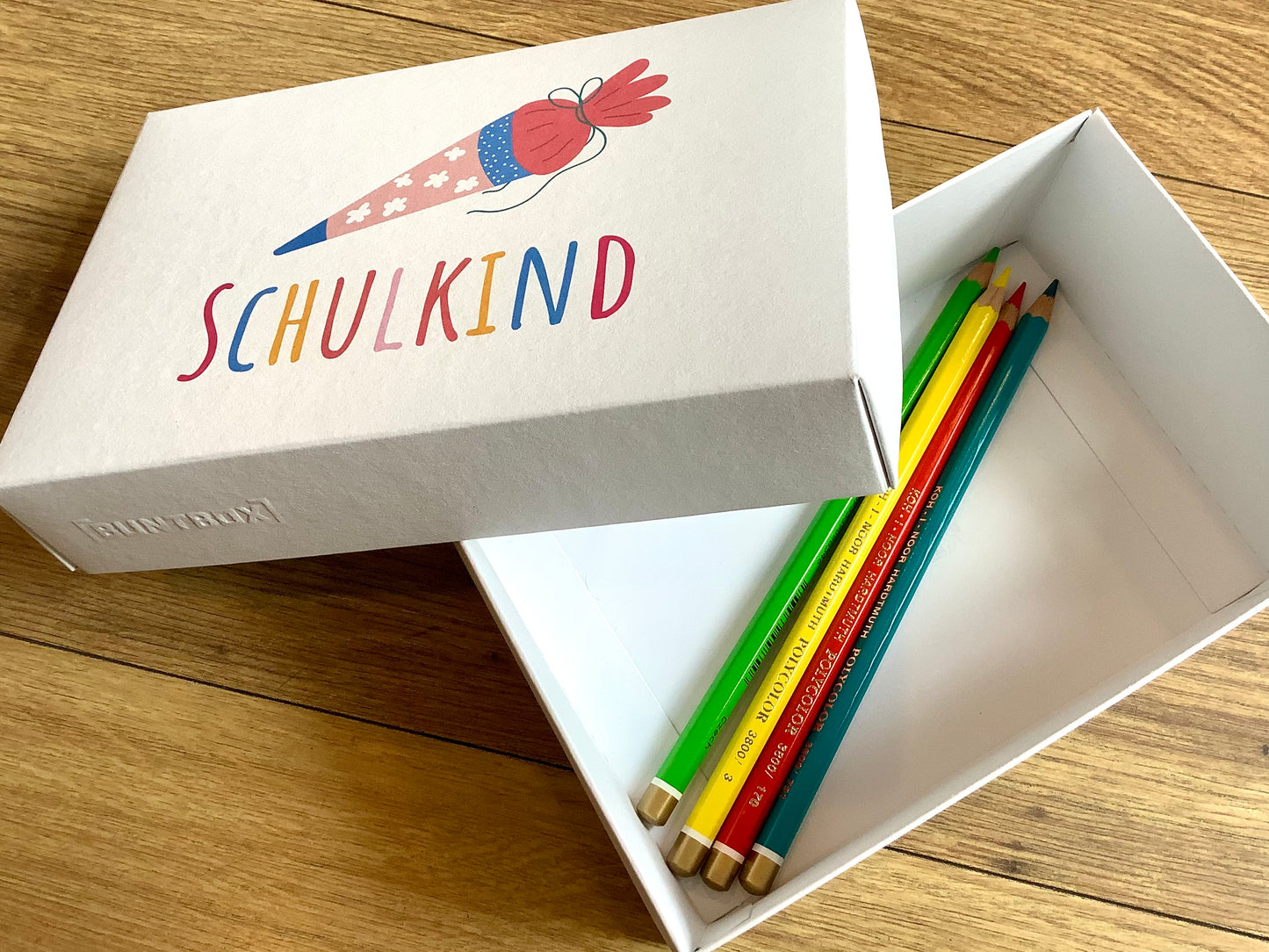 Geschenkschachtel mit dem bunten Aufdruck "Schulkind" und Schultüte -zum Schulstart. Erhältlich bei Polly Paper, umweltfreundlicher Schulbedarf in Berlin-Mitte
