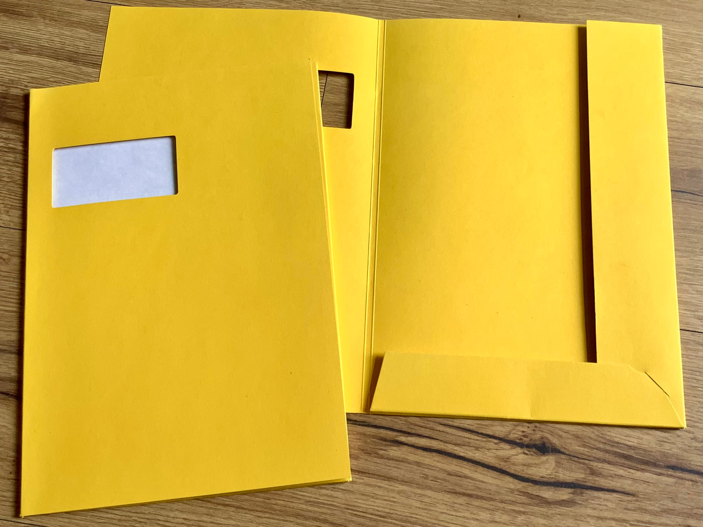 10 gelbe Pressemappen (Angebotsmappen) mit Fenster im Deckel und rechts zwei Flügel. Erhältllich bei Polly Paper Bürobedarf in Berlin-Mitte