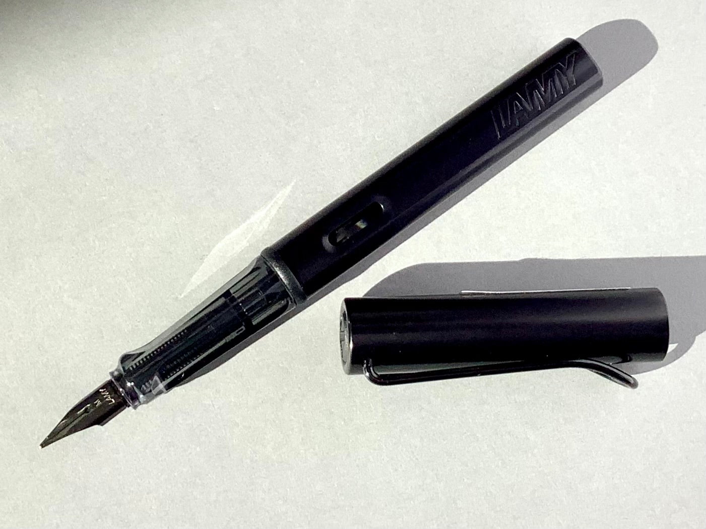 Füllhalter von LAMY aus Aluminium in schwarz (Griffstück aus transparentem Kunststoff). 
Erhältlich bei Polly Paper Schreibwaren in Berlin-Mitte