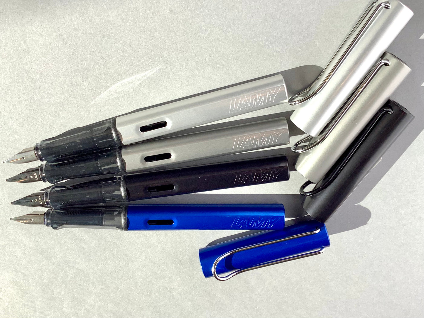 Füllhalter von LAMY aus Aluminium in blau, schwarz und silber (Griffstück aus transparentem Kunststoff). 
Erhältlich bei Polly Paper Schreibwaren in Berlin-Mitte