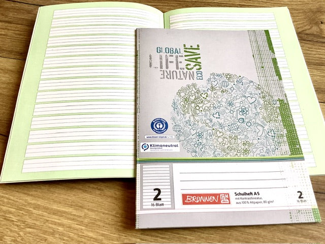 aufgeschlagenes A5-Schulheft mit der Lineatur 2 fürs 2. Schuljahr mit grünem Kontrasthintergrund.
Umweltfreundlicher Schulbedarf bei Polly Paper in Berlin-Mitte
