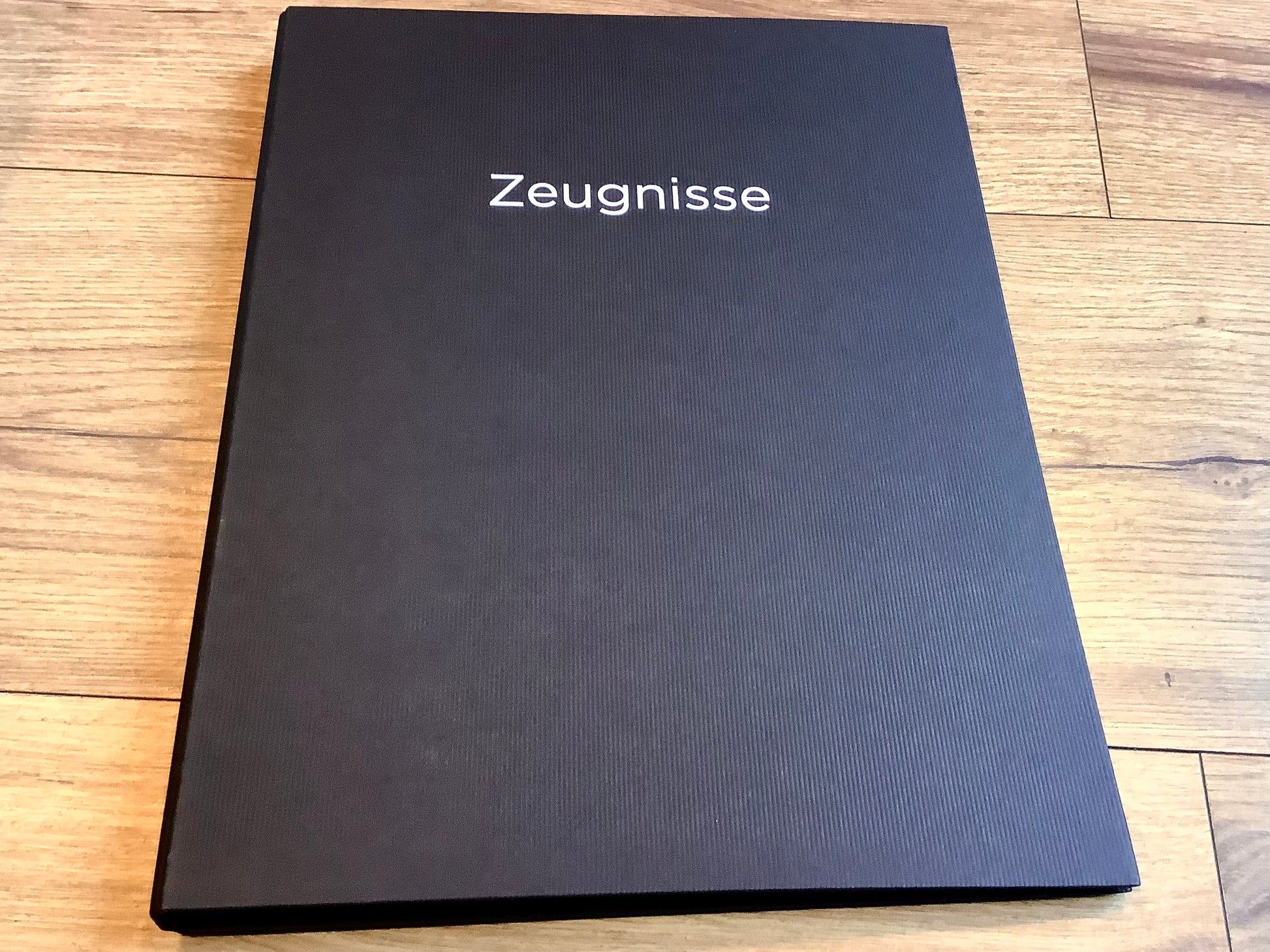 Schwarze Zeugnismappe mit silbernem Aufdruck "Zeugnisse" .
Diese Mappe und anderen Schulbedarf finden Sie bei Polly Paper in Berlin-Mitte