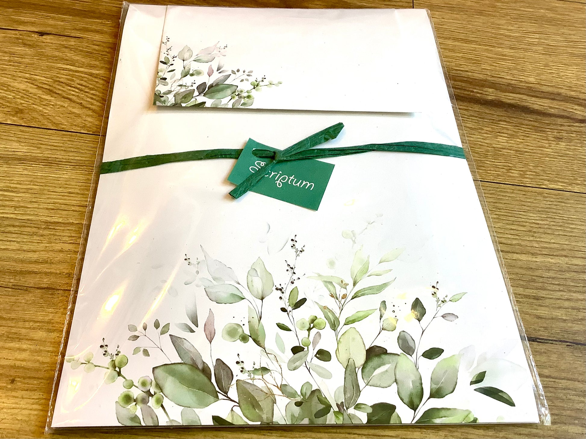 Briefpapier mit grünen Blättern unten