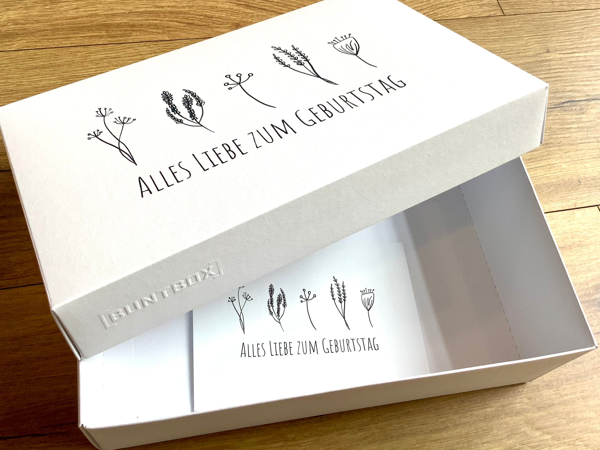 Geschenkschachtel mit dem Aufdruck "Alles Liebe zum Geburtstatg" und minimalistischen Blümchen. 
Erhältlich bei Polly Paper, umweltfreundlicher Geschenk-Bedarf in Berlin-Mitte