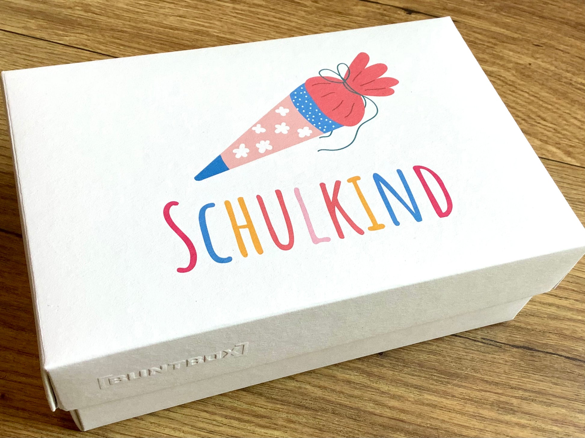 Geschenkschachtel mit dem bunten Aufdruck "Schulkind" und Schultüte -zum Schulstart. Erhältlich bei Polly Paper, umweltfreundlicher Schulbedarf in Berlin-Mitte