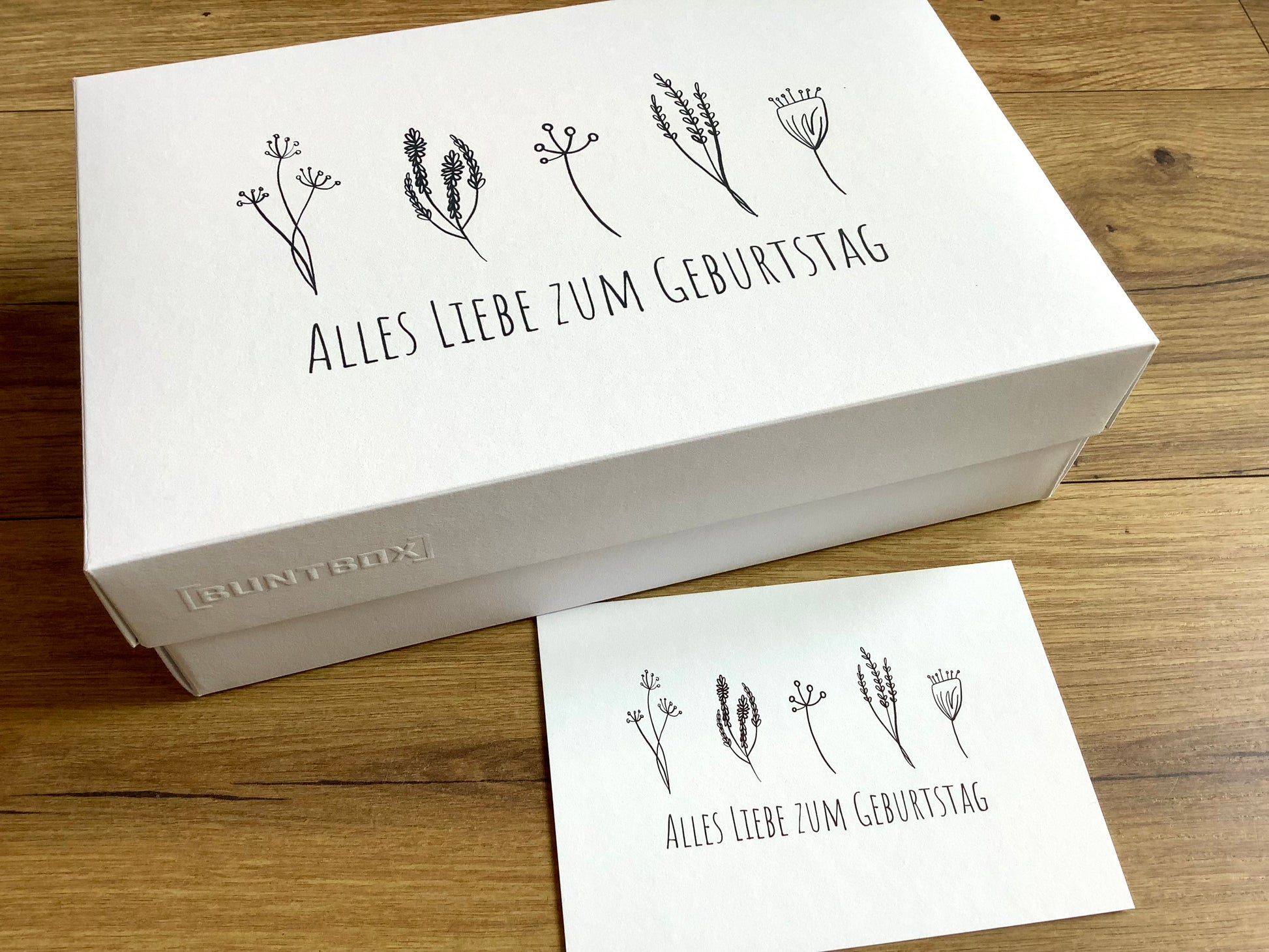 Geschenkschachtel mit dem Aufdruck "Alles Liebe zum Geburtstatg" und minimalistischen Blümchen. 
Erhältlich bei Polly Paper, umweltfreundlicher Geschenk-Bedarf in Berlin-Mitte