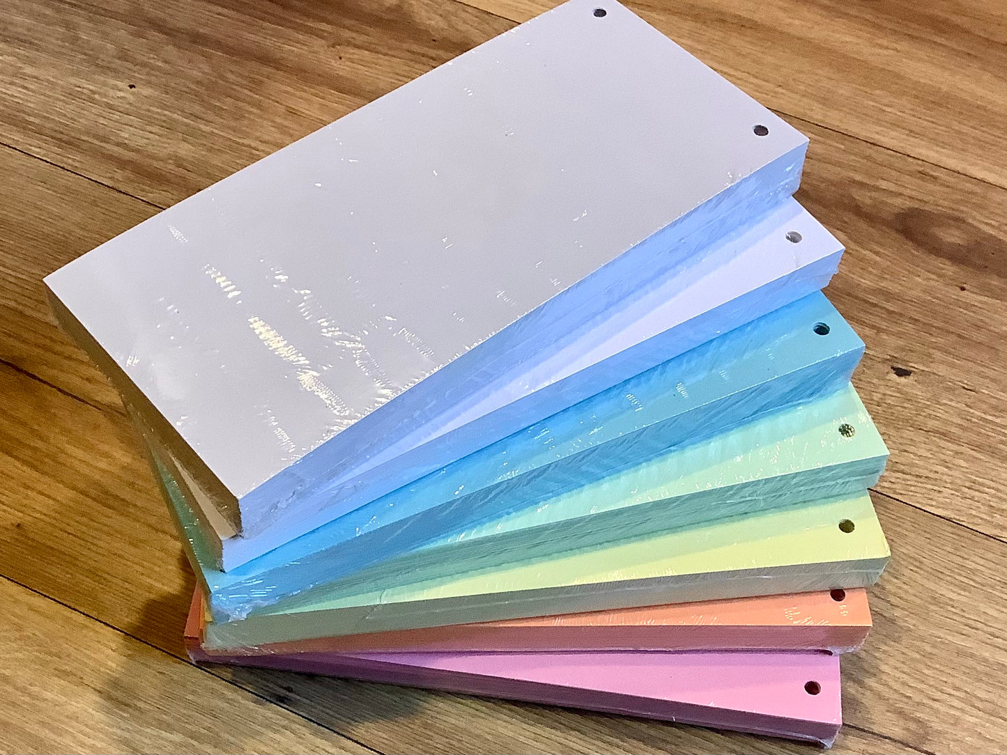 Trennstreifen aus Recyclingpapier in den Farben rosarot, orange, gelb, grün, blau, weiß und grau