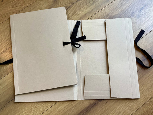 Graue Sammelmappe mit schwarzem Stoffband zum Verschließen