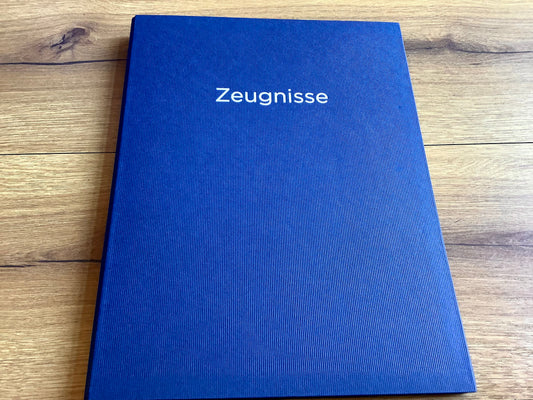 Blaue Zeugnismappe mit silbernem Aufdruck "Zeugnisse" .
Diese Mappe und anderen Schulbedarf finden Sie bei Polly Paper in Berlin-Mitte