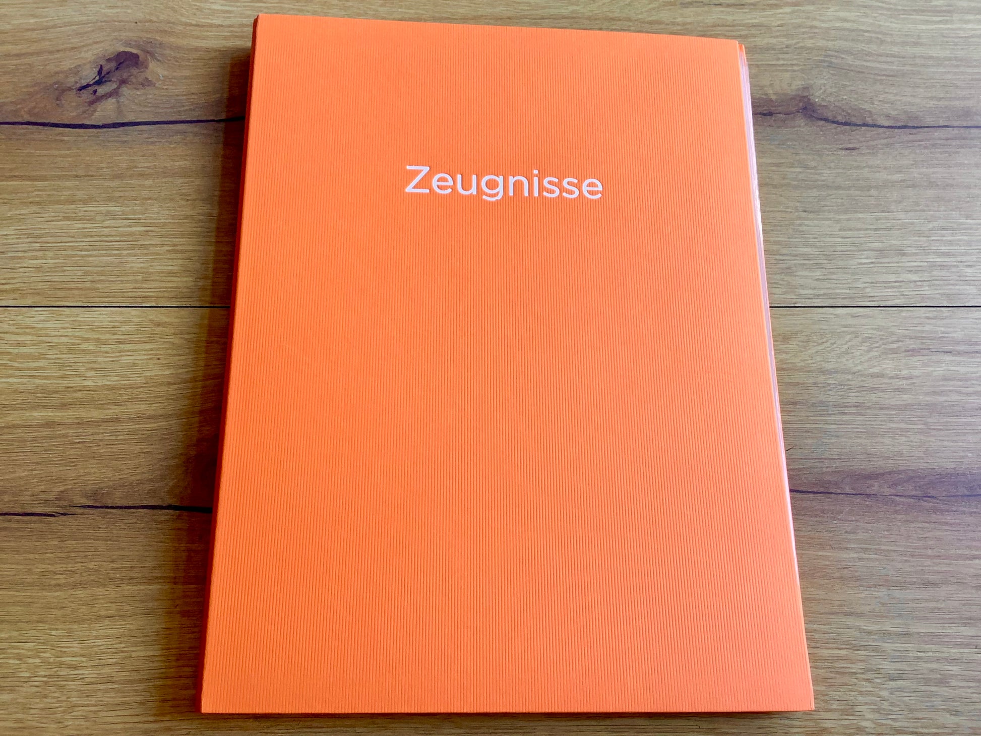 Orangefarbene Zeugnismappe mit silbernem Aufdruck "Zeugnisse" .
Diese Mappe und anderen Schulbedarf finden Sie bei Polly Paper in Berlin-Mitte