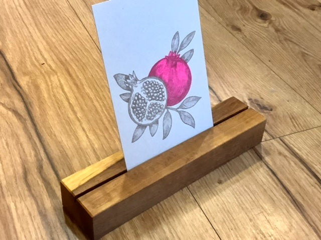 Nussbrauner Holzklotz mit Schlitz in der Mitte, um Fotos oder Karten hineinzustellen.
Erhältlich bei Polly Paper in Berlin-MItte
