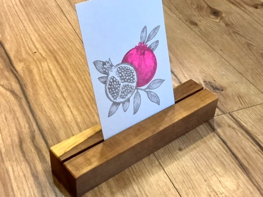Nussbrauner Holzklotz mit Schlitz in der Mitte, um Fotos oder Karten hineinzustellen.
Erhältlich bei Polly Paper in Berlin-MItte