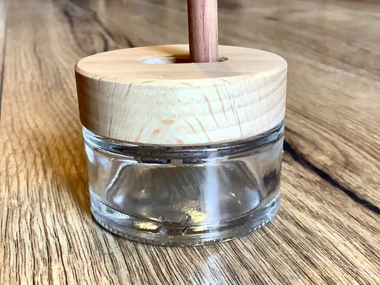 Glasbehälter mit Holzdeckel, in den ein Doppelspitzer für Blei- oder Buntstifte eingebaut ist