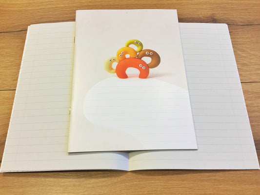 Ein liniertes Heft, das nicht nach Schule aussieht. Süße Knetfiguren auf dem Cover. 